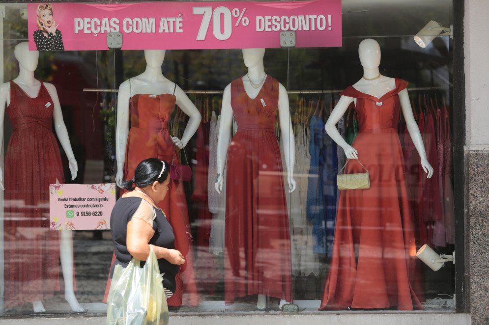 Vitrine de loja de vestidos com faixa de peças com até 70% de desconto durante a Black Friday