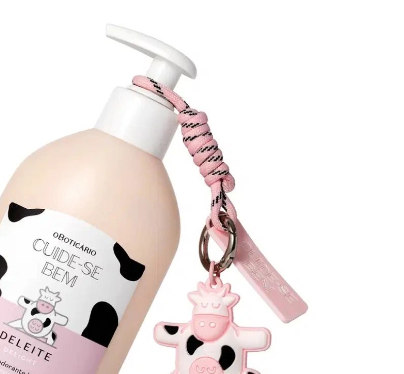 Hidratante Cuide-se Bem Deleite, de O Boticário, com charm de vaquinha pendurado no frasco