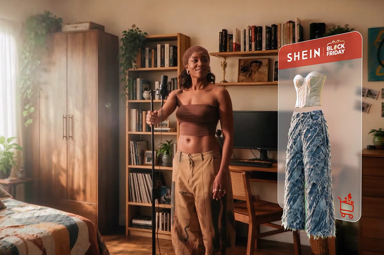 Cantora Iza em cena da campanha da Shein para Black Friday, ao lado de um painel com top e calça jeans