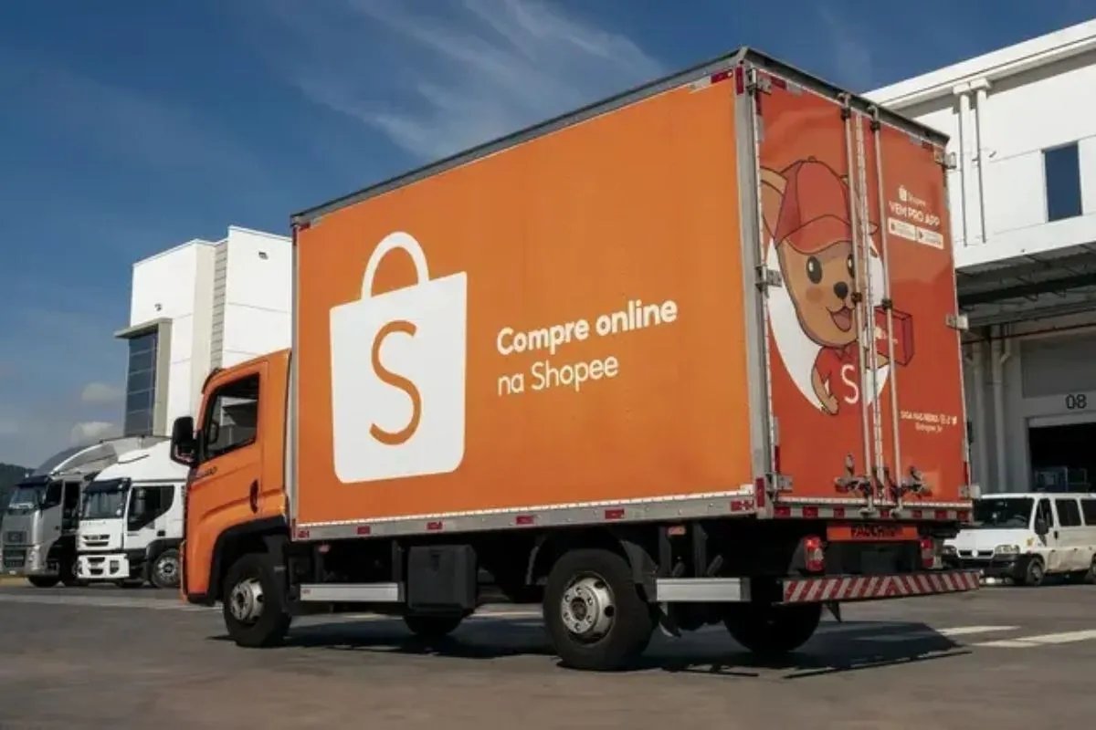 Caminhão de entregas da Shopee em frente a um centro de distribuição